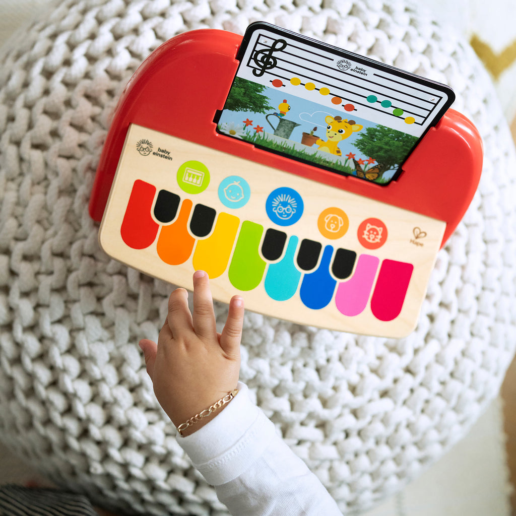 childs hand playing the piano